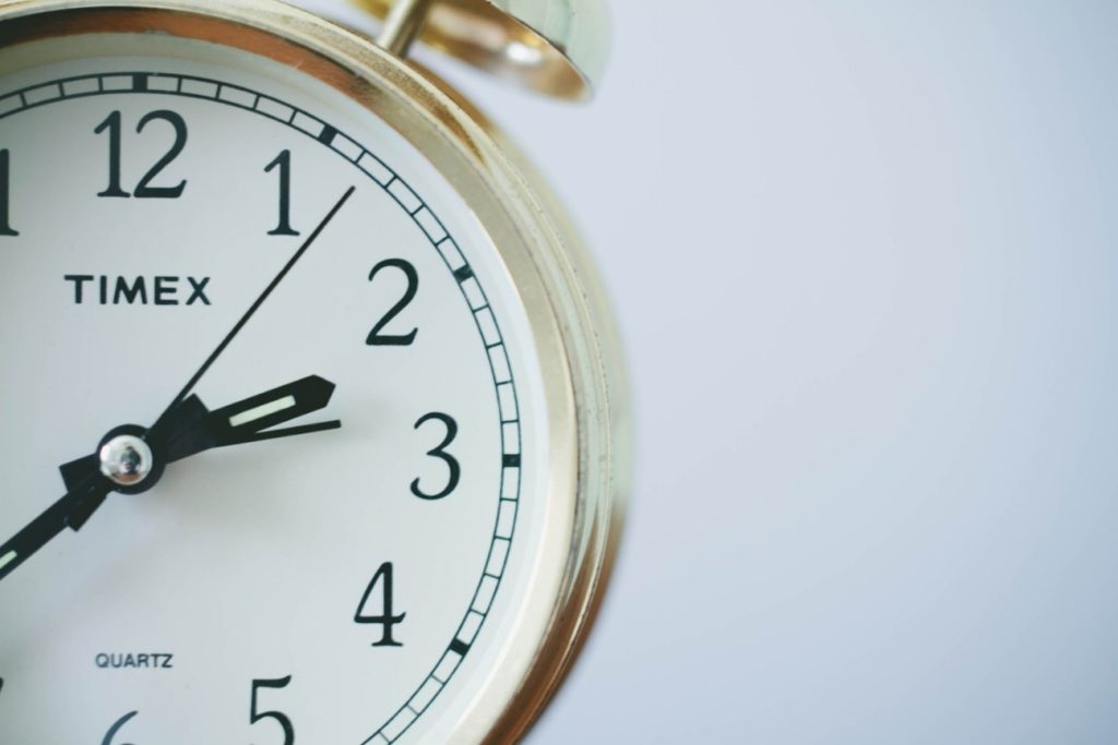 Imagem da metade de um relógio, demontrando a redução de jornada de trabalho